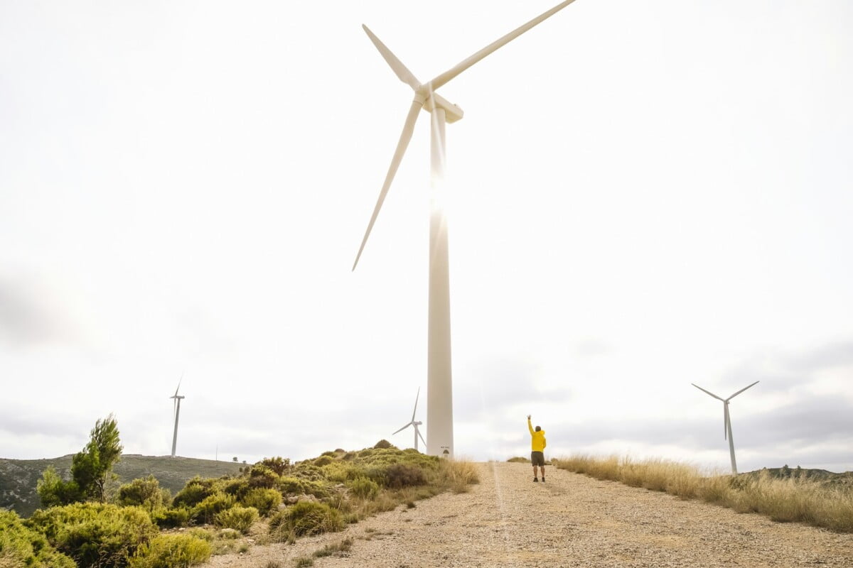 A man stands near the wind turbines A man stands near the wind turbines